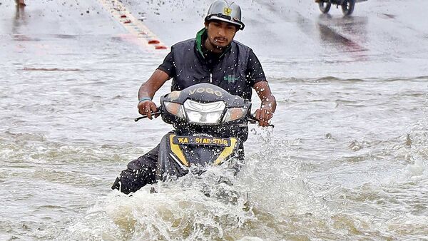 Bengaluru floods: A commuter wades through a waterlogged road following incessant rains (Shashidhar Byrappa)