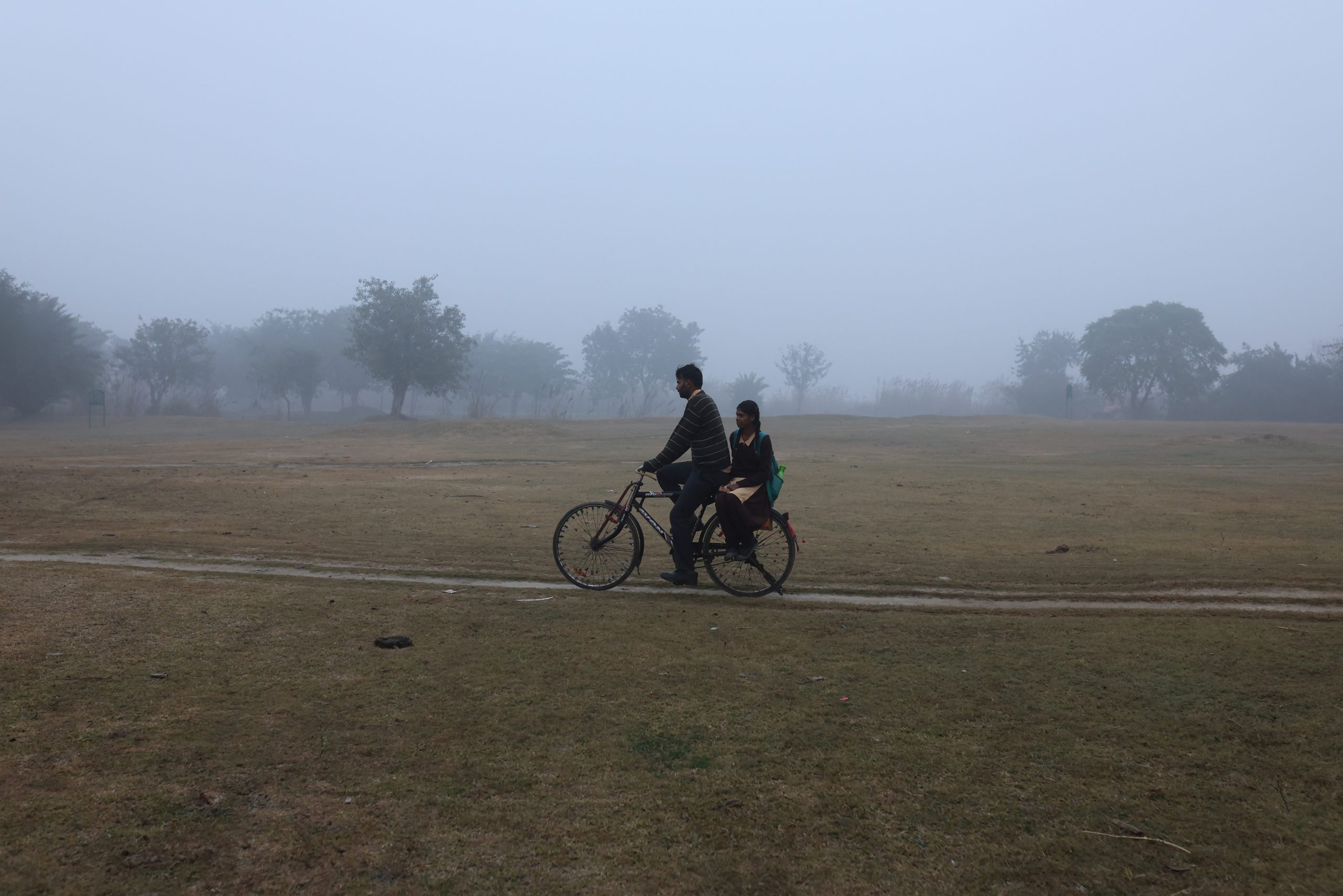 A man cycles with a schoolgirl on the pillion as they are on their way to school on a cold winter morning in New Delhi (Image/Reuters)
